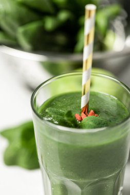 beyaz üzerinde ıspanak yaprakları yakınında saman ile cam lezzetli yeşil smoothie seçici odak 