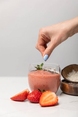 gri kırmızı çilek yakın lezzetli smoothie hindistan cevizi gevreği ekleyerek kadın kırpılmış görünümü 