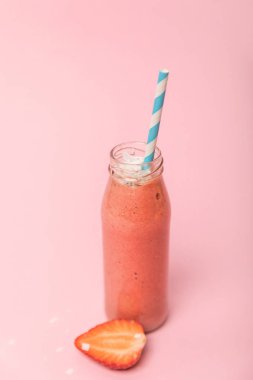 pembe kırmızı çilek yakın saman ile cam şişede tatlı ve lezzetli smoothie 
