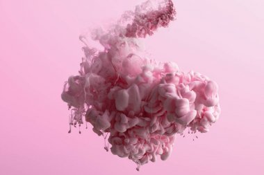 Pembe üzerine izole suda pembe boya girdaplarının yakın görünümü