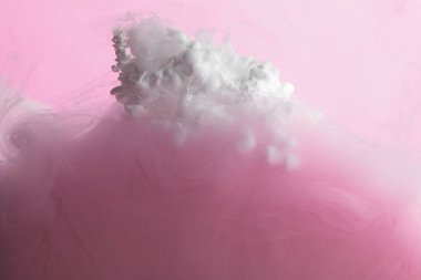 Pembe üzerine izole suda karıştırılan beyaz ve pembe boyanın yakın görünümü