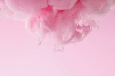 Pembe üzerine izole suda pembe boya girdaplarının yakın görünümü
