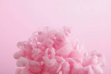 Pembe üzerine izole suda pembe boya girdaplarının yakın görünümü