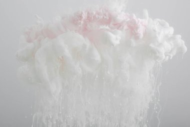 Gri üzerine izole akrilik açık pembe boya girdapları yakından görünümü