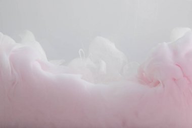 Gri üzerine izole edilmiş açık pembe boya girdaplarının yakın görünümü