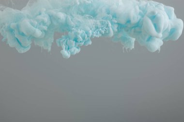 Gri üzerinde izole soyut mavi mürekkep girdaplarının yakın görünümü