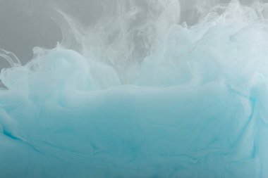 Gri üzerine izole edilmiş soyut mavi boya girdaplarının yakın görünümü