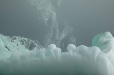 Gri üzerine izole edilmiş açık yeşil boya girdaplarının yakın görünümü 