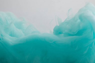 Gri üzerine izole turkuaz boya girdapları yakından görünümü