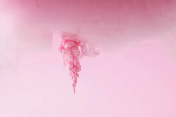 Close up view of pink paint splash in water isolated on pink