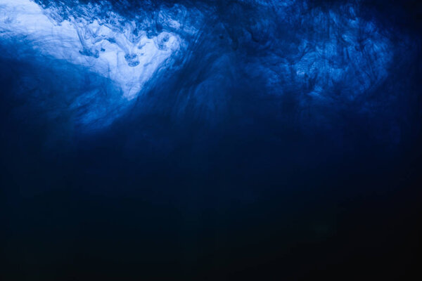 Close up view of dark blue paint swirls in water