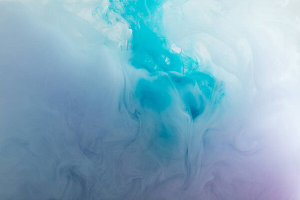 Close up view of blue and purple smoky paint swirls in water 