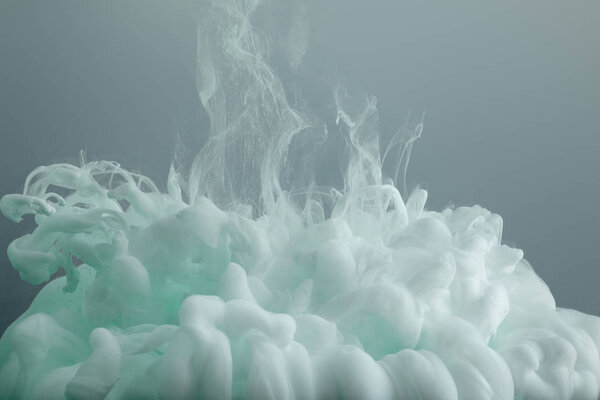 Close up view of light green paint swirls isolated on grey 