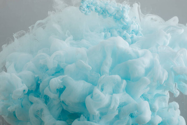 Close up view of light blue paint swirls isolated on grey