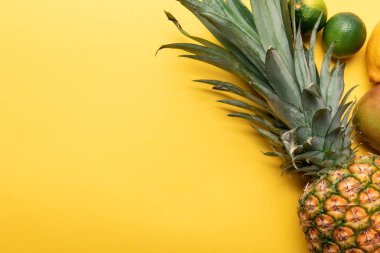 tüm olgun ananas üst görünümü, narenciye ve mango sarı arka plan üzerinde