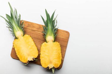 kopya alanı ile beyaz arka plan üzerinde ahşap doğrama tahtası üzerinde kesilmiş olgun sarı ananas üst görünümü
