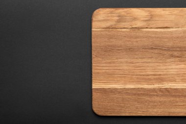 top view of empty wooden cutting board on black background clipart