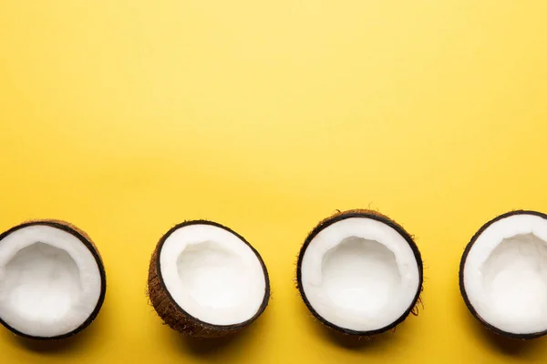 Top Zicht Rijpe Kokos Helften Gele Achtergrond Met Kopieer Ruimte — Stockfoto