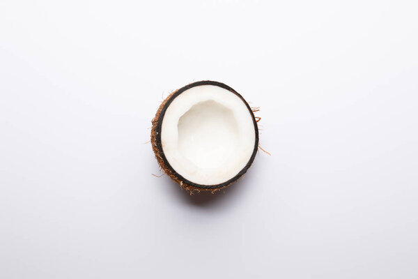 top view of ripe coconut half on white background with copy space
