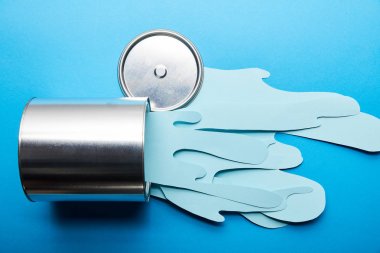 top view of spilled paper cut blue paint near silver shiny can and cap clipart