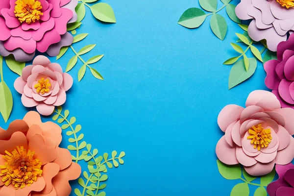 Widok Góry Wielokolorowe Papierowe Kwiaty Cięte Zielonych Liści Niebieskim Tle — Zdjęcie stockowe