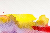 Nahaufnahme von gelben, lila und roten Aquarellfarben auf weißem Hintergrund mit Kopierraum