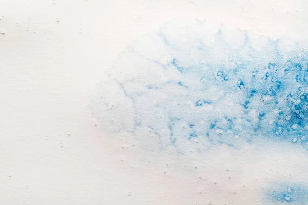 blue watercolor paint spill on white background with copy space