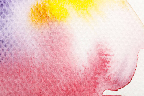 вид сверху на желтый, фиолетовый и красный цвет акварели бледные разливы краски на белом фоне
