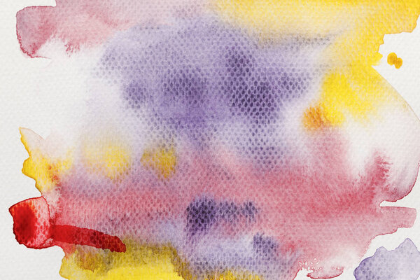 top view of yellow, purple and red watercolor paint spills on textured background