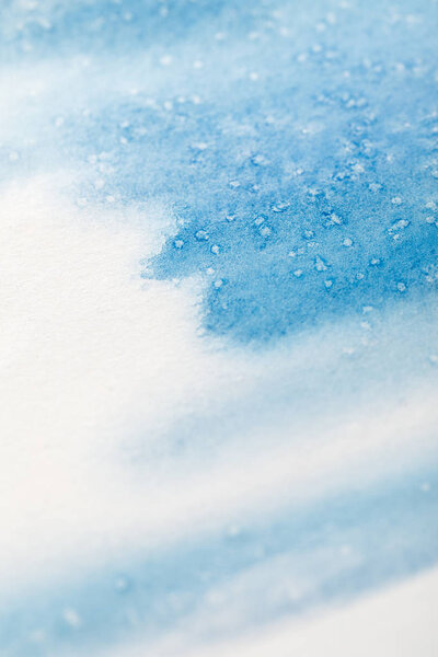 close up view of blue watercolor paint brushstrokes with dots on white background 