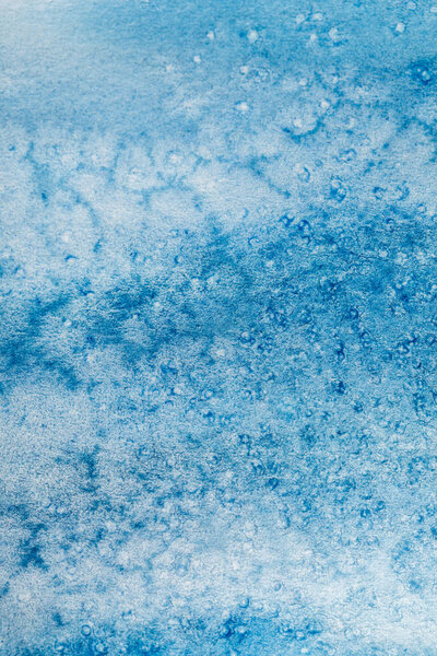 close up view of blue watercolor paint stain on textured background 