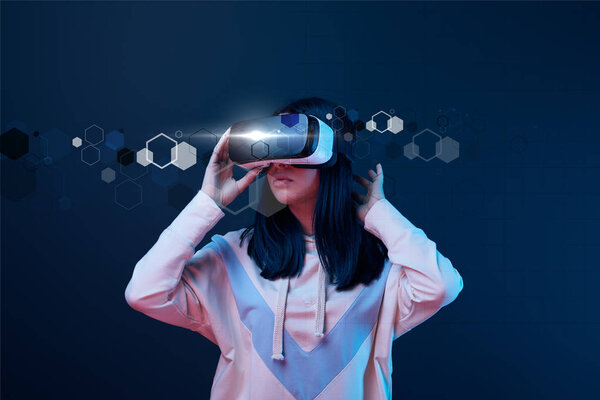 young woman in virtual reality headset among cyber illustration on dark background