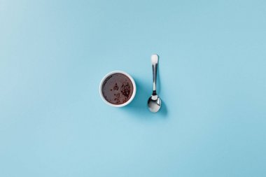 top view of teaspoon near jam in bowl on blue background clipart