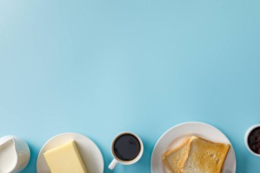 süt, tereyağı, reçel, kahve fincanı ve mavi arka plan üzerinde beyaz tabaklar üzerinde iki tost üst görünümü