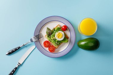 mavi arka plan guacamole, avokado ve portakal suyu ile tost üst görünümü