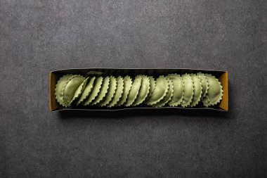 gri dokulu yüzeyüzerinde karton kutu yeşil ham ravioli üst görünümü