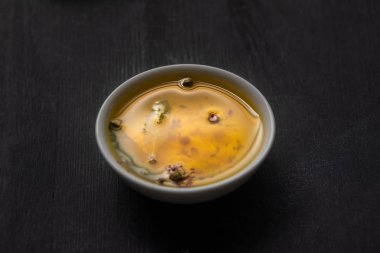 ahşap siyah masa üzerinde baharat ve otlar ile kapta aromatik yağ