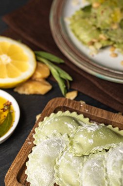 ahşap tahta üzerinde un ile yeşil ham ravioli seçici odak
