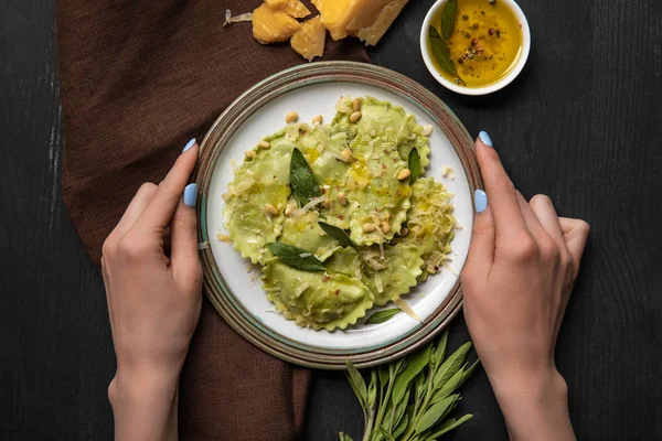 Top View Woman Holding Plate Delicious Ravioli Black Wooden Table — Stock Photo, Image