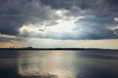 Nehir kıyı şeridi, bulutlu hava ve güneş ışığı ile bulutlar
