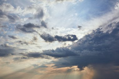 dark clouds and sun rays on blue sky background