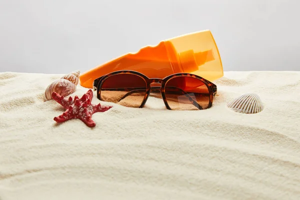 Bruine Stijlvolle Zonnebrillen Zand Met Rode Zeester Schelpen Zonnebrandcrème Oranje — Stockfoto