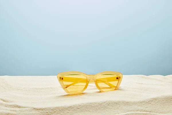 Gelbe Stylische Sonnenbrille Auf Sand Auf Blauem Hintergrund — Stockfoto