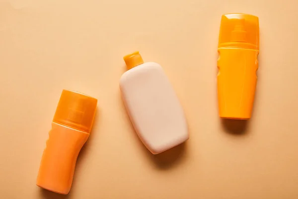 米色背景瓶中防晒产品的顶视图 — 图库照片