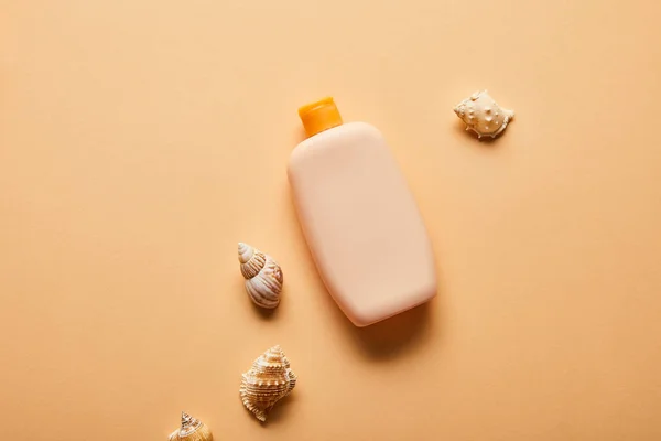 Top Zicht Van Zonnebrandcrème Fles Bij Schelpen Beige Achtergrond — Stockfoto