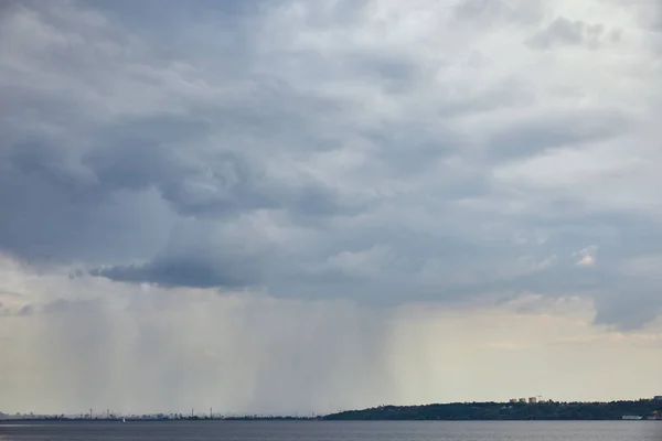 overcast view of blue and grey clouds upon forest coast 