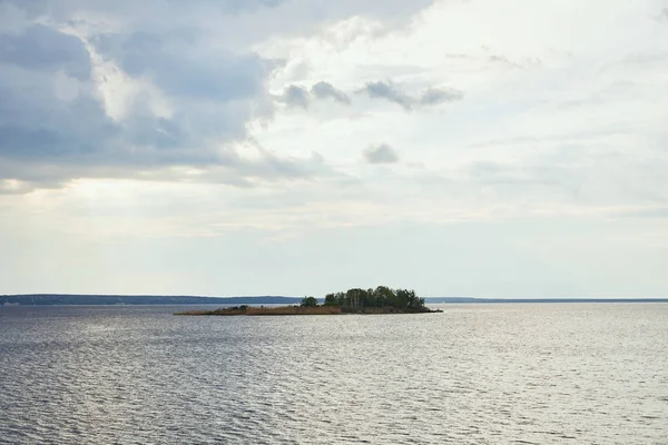 sunny weather with blue clouds on white sky background upon small island with forest