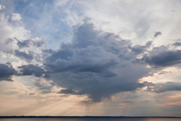 dark cloud and sun rays on blue sky background