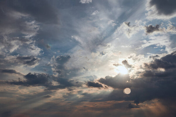 dark clouds and sun rays on blue sky background