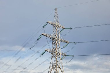 view of electric pole with long wires on grey sky background clipart